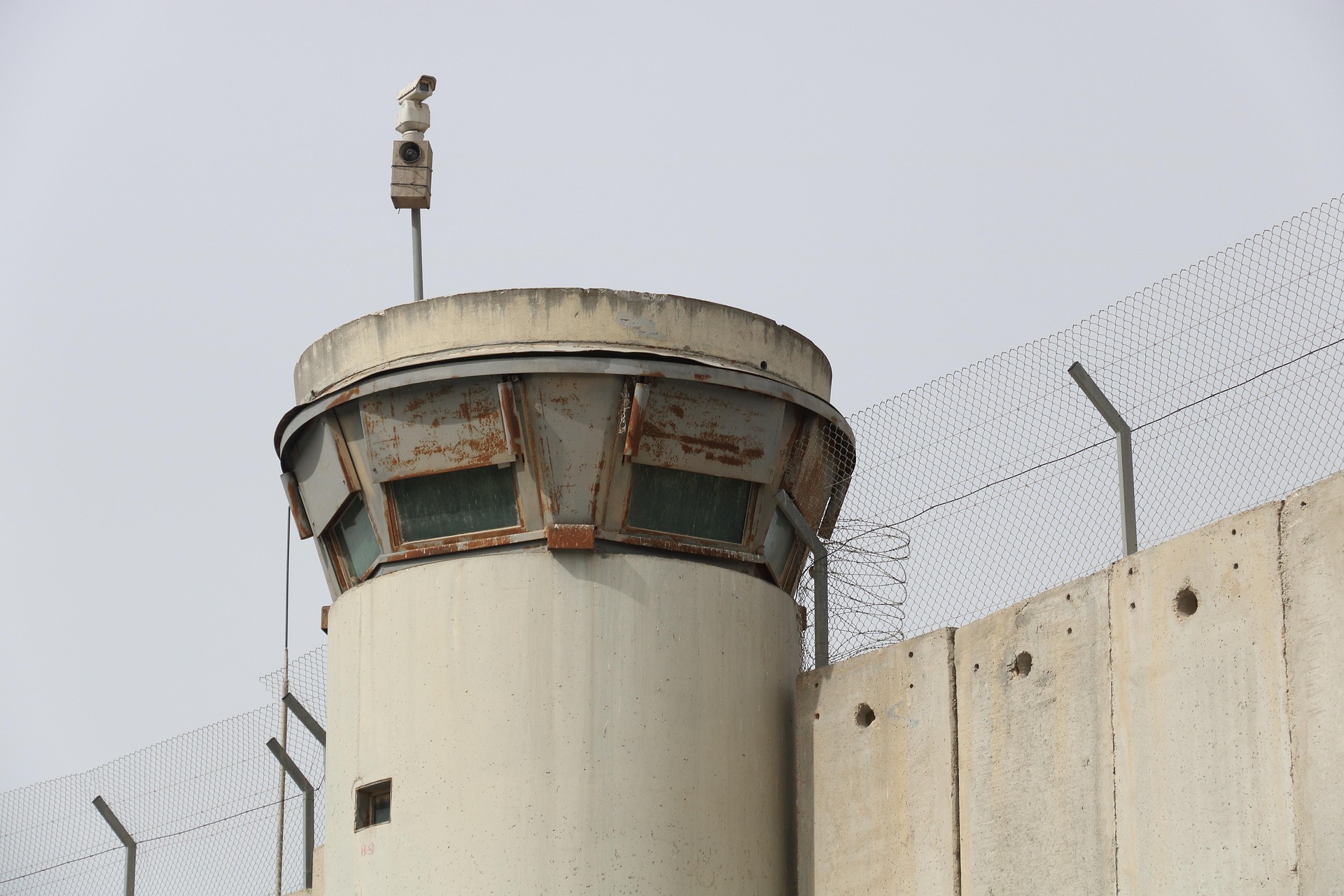 A big wall in isreal with a video camera mounted on it.